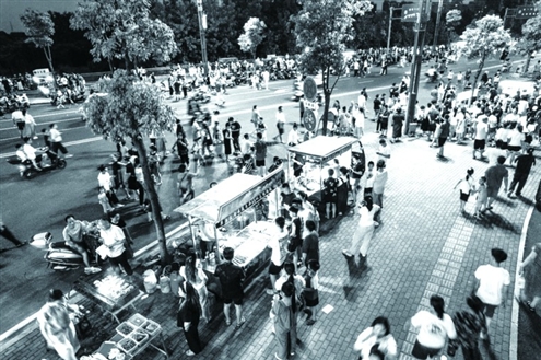 7月12日,湖南某市一夜市吸引众多游客驻足